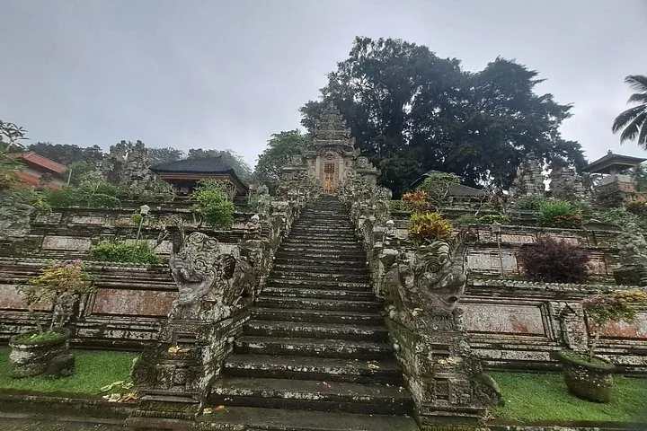 Steintreppen, die zu einem kunstvoll verzierten Eingang eines traditionellen balinesischen Tempels hinaufführen.
