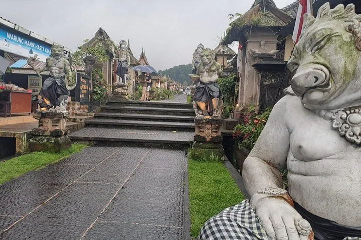 Steinstatuen bewachen den Eingang zu einer traditionellen balinesischen Dorfstraße.